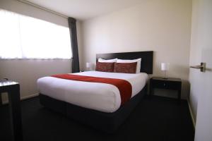 a hotel room with a large bed and a window at Metropolitan Motel on Riccarton in Christchurch