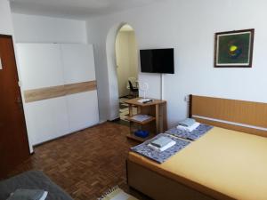 ein Hotelzimmer mit einem Bett und einem Fernseher in der Unterkunft Apartmani Laura in Trogir