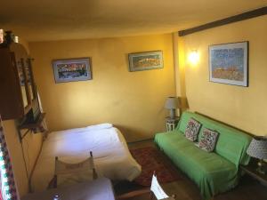 ein Wohnzimmer mit einem grünen Sofa und einem Bett in der Unterkunft Estudio El Zoco in Granada