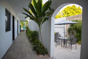 un patio con una mesa y una palmera en Margarett Hotel en Valladolid