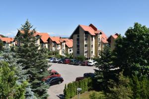 a parking lot with cars parked in front of a building at House Violeta in Nida
