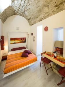 a bedroom with a large bed and a table at La Casa dei Nonni in Giardini Naxos