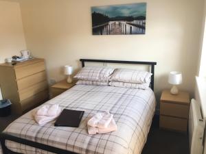 a bedroom with a bed with two towels and a laptop at Cherish End Guest House in Dunstable