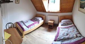 two beds in a small room with a window at Penzion Na Bařinách in Valašská Bystřice