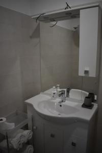 La salle de bains blanche est pourvue d'un lavabo et d'un miroir. dans l'établissement Da Nonna Laura al Circeo, à San Felice Circeo