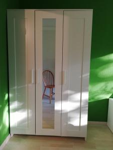 皮爾納的住宿－Ferienwohnung Angelo，客房内的白色橱柜和椅子