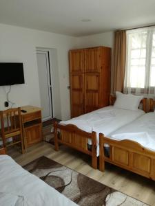 a bedroom with two twin beds and a television at Къща Генчеви in Sarnitsa