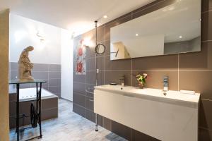 a bathroom with a sink and a statue in it at La maison de Raphaël in Tournon-sur-Rhône