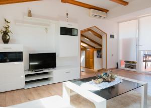 ein Wohnzimmer mit einem TV und einem Glastisch in der Unterkunft Apartments Alma in Crveni Vrh