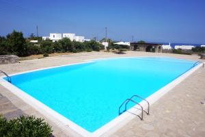 a large swimming pool with blue water at Sunset Villa I in Agia Irini Paros