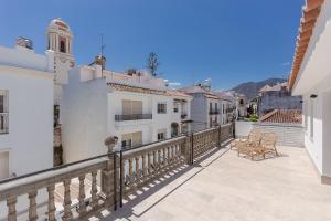 a balcony of a white building with a clock tower at Chacón Apartments & Suites in Estepona