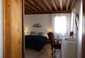 1 dormitorio con cama, mesa y ventana en Appartamenti San Luca en Venecia