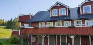 a red house with a black roof at Skutskepparn Kuststation in Nordingrå
