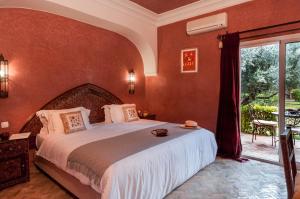 sypialnia z dużym łóżkiem i dużym oknem w obiekcie Charming villa in the heart of Marrakech palm grove w Marakeszu