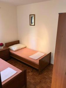 een kamer met twee bedden en een foto aan de muur bij Put Lokvice 50 in Novalja