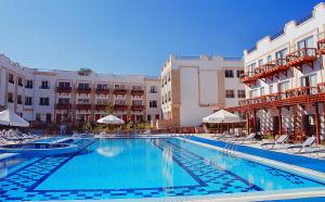 a large swimming pool in front of some buildings at Falcon Naama Star Hotel in Sharm El Sheikh
