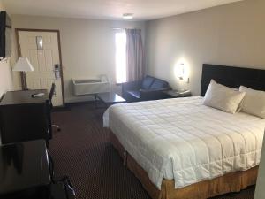 um quarto de hotel com uma cama e um sofá em Friona Inn em Friona