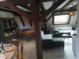 een woonkamer met een bank en een tafel bij Gîte Les papillons in Ribeauvillé