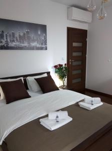 1 dormitorio con 1 cama grande y toallas. en Apartament H&P Silver en Varsovia