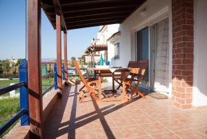 eine Terrasse mit einem Tisch und Stühlen auf dem Balkon in der Unterkunft Villa Arogi in Aroyí