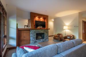 モントランブランにあるTremblant Prestige - Étoile 1520-3の青いソファと暖炉のあるリビングルーム