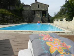 a swimming pool with a person in the background at Chambre Cévennes: Piscine, lamas, rivière in Cros