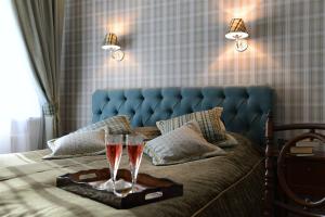 Una cama con dos copas de champán en una bandeja en Vila Klasika en Birštonas