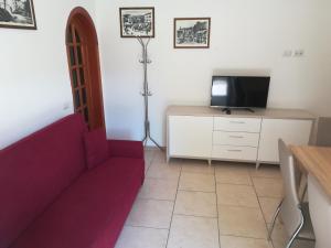 a living room with a red couch and a tv at Appartamento Lo Slittone in Abetone