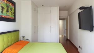 1 dormitorio con 1 cama y TV de pantalla plana en Amazing Apartment in Miraflores Larcomar, en Lima