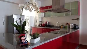 una cocina con armarios rojos y una encimera con una muñeca. en Amazing Apartment in Miraflores Larcomar, en Lima
