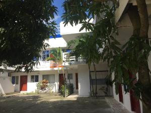 a white building with trees in front of it at Hostal Sarai in Pedernales