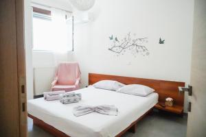 a bedroom with a bed with a pink chair at Georgia's House in Galatas