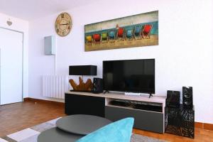 a living room with a flat screen tv and speakers at Le Long Beach - Leconfortalaplage in Le Barcarès