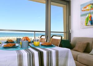 stół z jedzeniem i widokiem na plażę w obiekcie Le Long Beach - Leconfortalaplage w mieście Le Barcarès