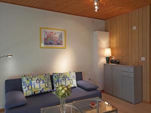 ein Wohnzimmer mit einem blauen Sofa und einem Tisch in der Unterkunft Casa Sibylle bei Locarno in Locarno