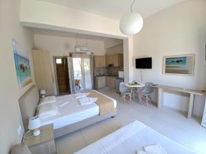 a bedroom with a large bed and a kitchen at Minimalistic Apartment Near the Sea in Gouves