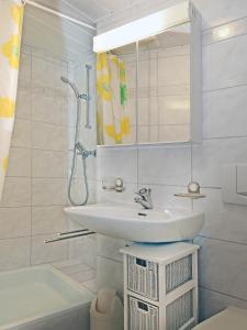 uma casa de banho com um lavatório, um espelho e uma banheira em Casa Sibylle bei Locarno em Locarno