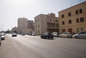 a group of cars driving down a street with buildings at Affittacamere Arcobaleno in Trapani