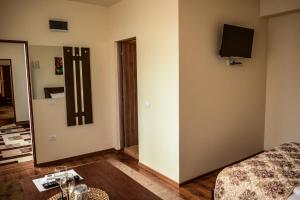 um quarto com uma cama e uma televisão na parede em Martin'Suite em Alba Iulia