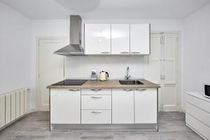 a kitchen with white cabinets and a sink at New Apartment Explanada in Alicante
