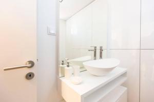 bagno bianco con lavandino e specchio di Seaside With a View - 200m away from the beach! a Cascais