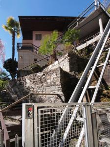 a building with a gate in front of a stone wall at Casa Sibylle bei Locarno in Locarno