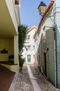 un vicolo tra due edifici con una porta verde di Seaside With a View - 200m away from the beach! a Cascais