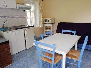 a kitchen and dining room with a white table and chairs at Maison MooMoons in Vaubadon