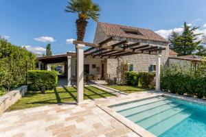 une villa avec un palmier et une piscine dans l'établissement Villa Draga Paradise pool villa in Split, à Solin