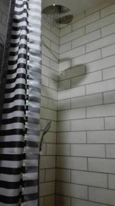 a shower with a black and white tile wall at Azoka by the Sea- Centro Histórico de Peniche in Peniche