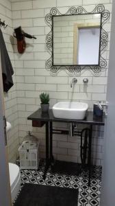 uma casa de banho com um lavatório e um espelho em Azoka by the Sea- Centro Histórico de Peniche em Peniche