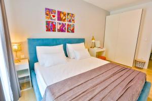 a bedroom with a large white bed with a blue headboard at Luxury Urban Villa Apartments With Jacuzzi in Split