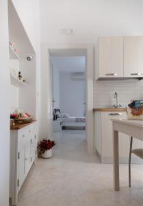 une cuisine avec des placards blancs et une table. dans l'établissement La Casa di Ninetta Amalfi Coast, à Vietri