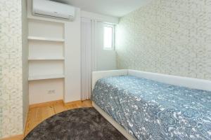 a bedroom with a bed and a wall with shelves at Cascais Seaside Duplex - 200m from the beach! in Cascais